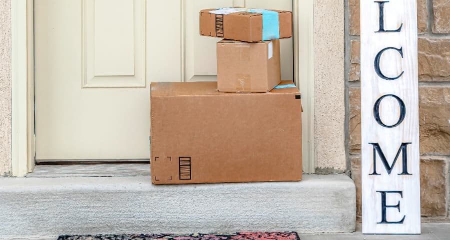 Packages on the doorstep of a home with a welcome sign in Fort Wayne